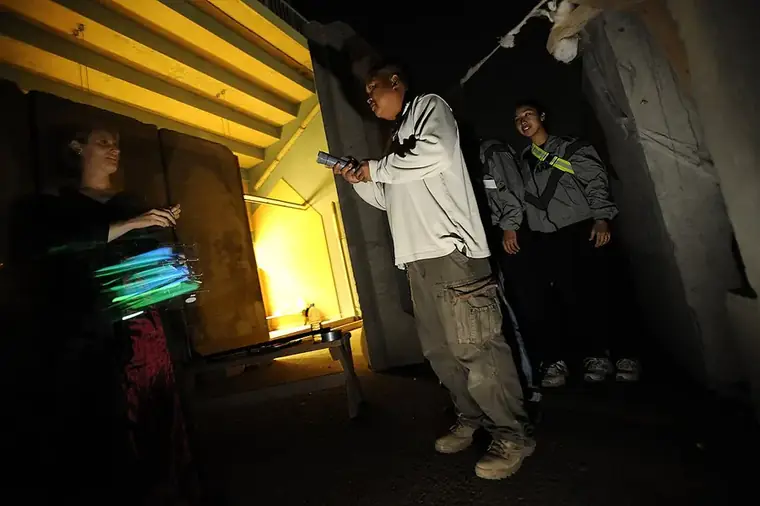 Visitors with glow sticks in a dark haunted-house hallway